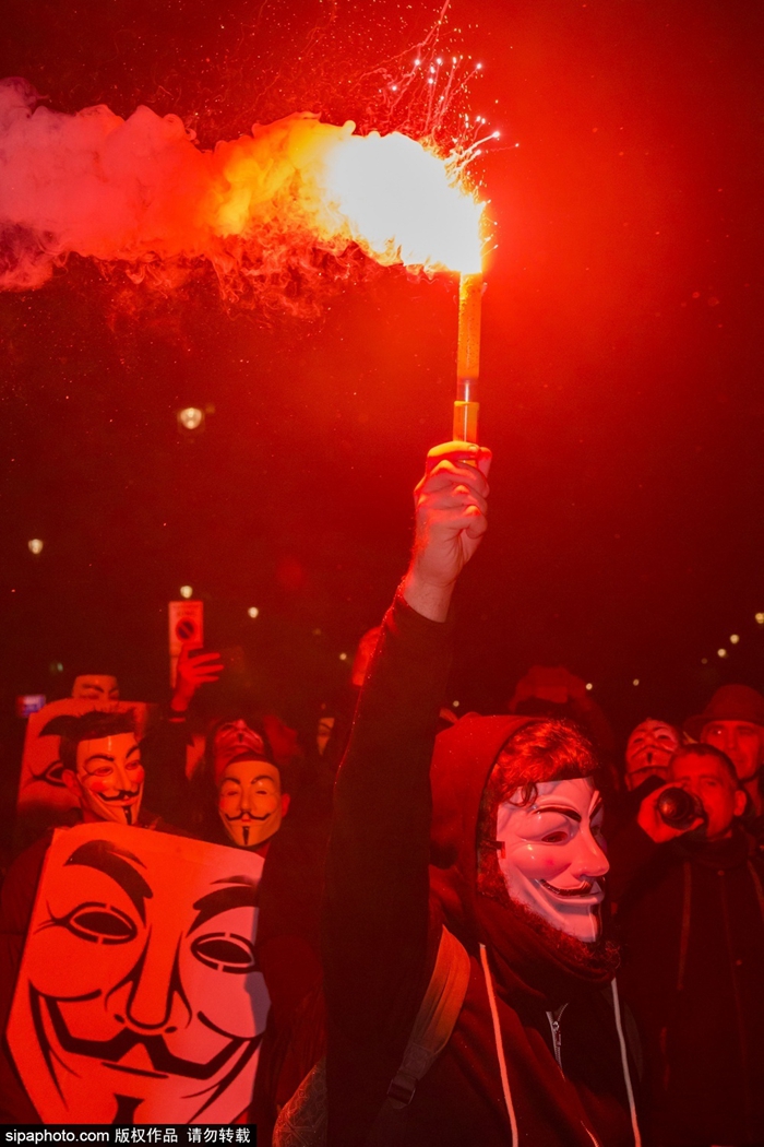 戴着电影《v字仇杀队》里主角"v怪客"的面具参加百万面具游行(million