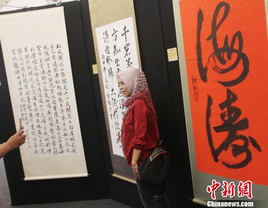 图为印尼青年在中国书法作品前留影。　林永传 摄