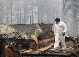 搜救人员在山火过后的废墟工作